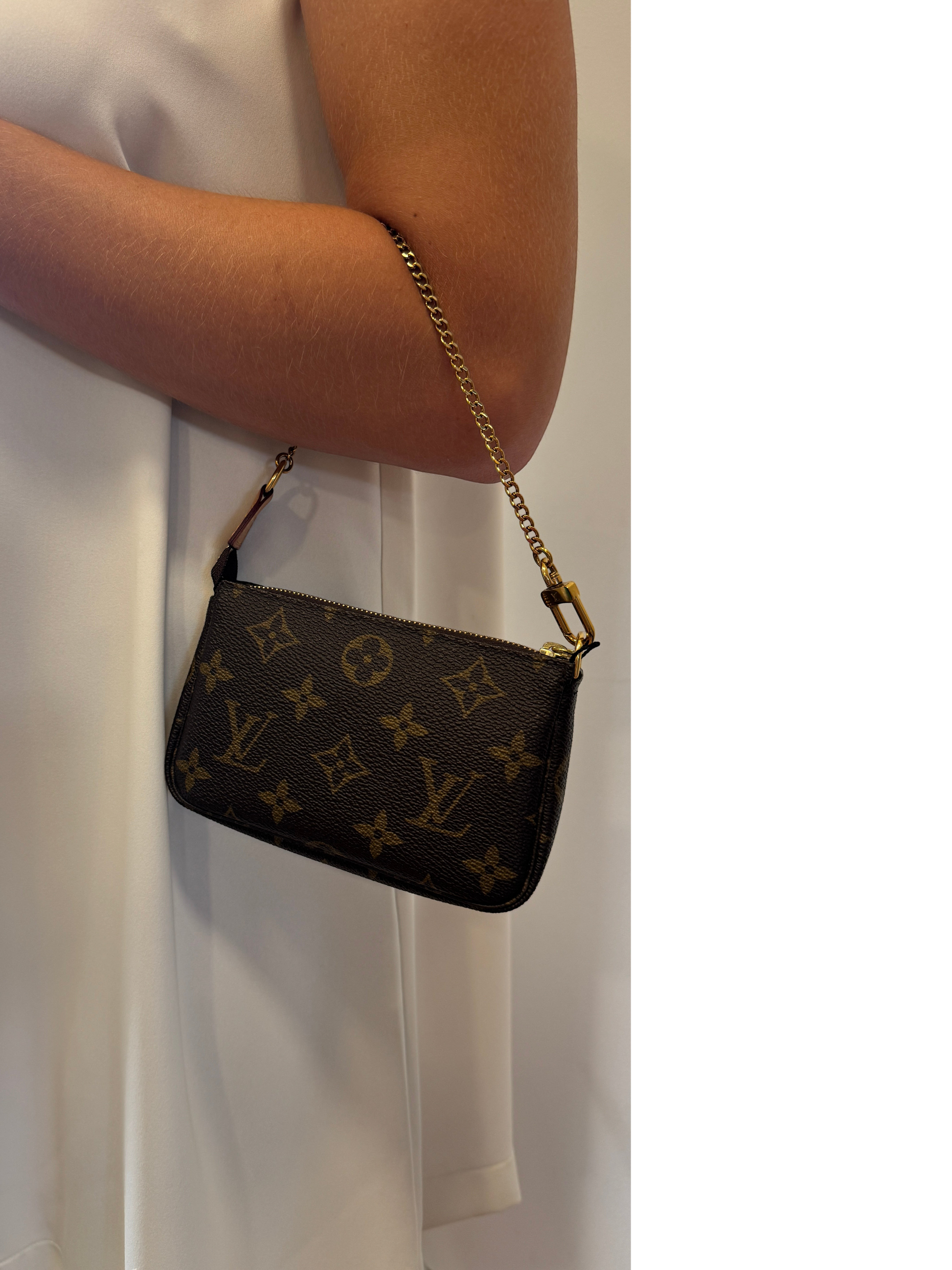 Brandsamsara Louis Vuitton Monogram Mini Pochette handbag in brown leather with a gold chain strap worn on the arm